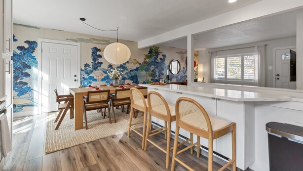 A modern kitchen with a white countertop, wooden chairs, and a dining table. - 5BD Japanese-Themed w/ Hot Tub, Movie Room & Games (Arvada)