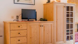 Un mobile in legno con cassetti e una televisione sopra.