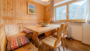 Un interno in legno con un tavolo da pranzo, panche e sedie.