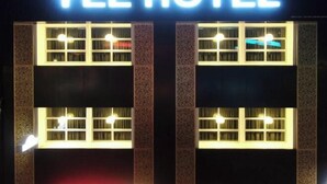 Das YEE HOTEL mit beleuchteter Beschilderung und fensterartigen Mustern.