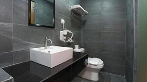 Ein modernes Badezimmer mit Waschbecken, Spiegel, Toilette und Handtuchhalter.