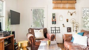 Una sala de estar con sofás de cuero, una mesa de centro y elementos decorativos en la pared.