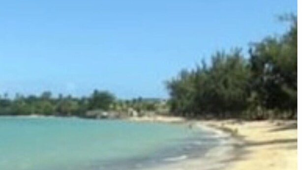 Een strand met helder turquoise water en een zandkust.