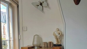 A wooden cabinet with two doors, a crystal pyramid, and a sculpture on top. - Cosy Parisian charm Paris 12e Montgallet  (Paris)