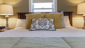 A neatly made bed with a clock, two bedside lamps, and a window with blinds. - Bungalow #5 by Polo House and Bungalows (Santa Ynez)