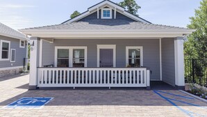 A single-story building with a covered porch, a wheelchair-accessible ramp, and a small window on the front.