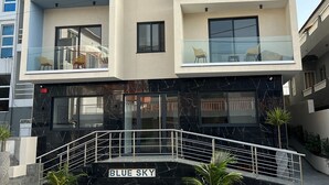 A multi-story building with balconies, a staircase, and a sign reading "BLUE SKY". - Hotel Blue Sky (Tarrafal)