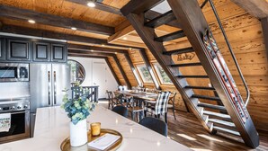 Eine moderne Küche mit Edelstahlgeräten, einer Marmorarbeitsplatte und einem Essbereich mit Holztisch und Stühlen.