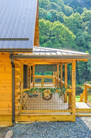 Una cabaña de madera con un letrero que dice 'RIVERSTEAD' y el número '177' en el lateral.