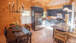 Una cocina moderna con una isla central, electrodomésticos de acero inoxidable y armarios de madera.