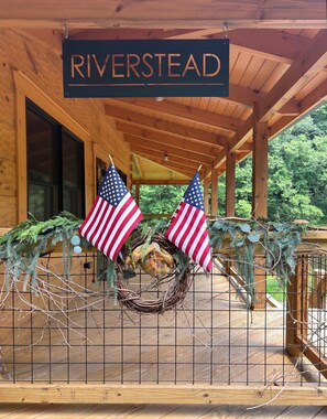 A wooden cabin with a sign reading 'RIVERSTEAD' above the entrance.