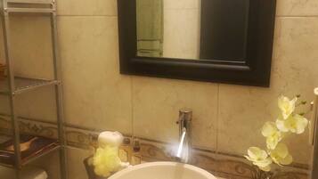 A bathroom with a white sink, a mirror, and a towel rack.