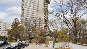 Un edificio de varios pisos con un diseño arquitectónico moderno, que incluye varias balcones y un techo plano.