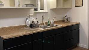 A kitchen with white cabinets, a granite countertop, and a stainless steel sink.