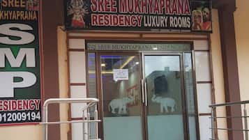 A hotel entrance with a sign for Sree Mukhyaprana Residency Luxury Rooms.