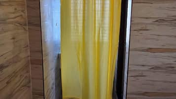 A room with wooden paneling and a yellow curtain.