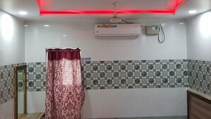 Un baño con cortina de ducha, ventilador de techo y aire acondicionado.