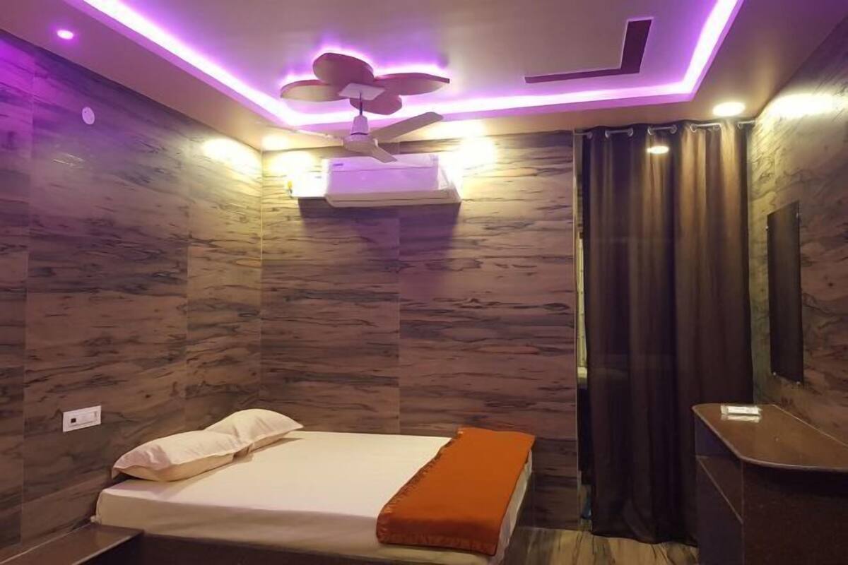 A modern bedroom with a bed, a ceiling fan, and a wall-mounted air conditioner.