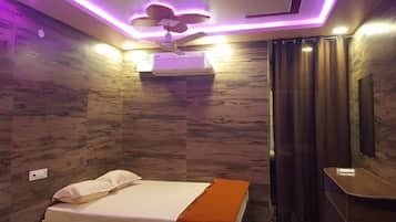 Una camera da letto moderna con un letto, una ventola a soffitto e un condizionatore d'aria fissato al muro.