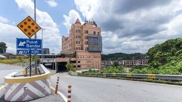 A road sign indicating direction to Pusat Bandar and Kut Kiri, with a building in the background.