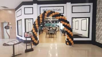 An entrance to a cafe with a black and white geometric wall design and a balloon archway.