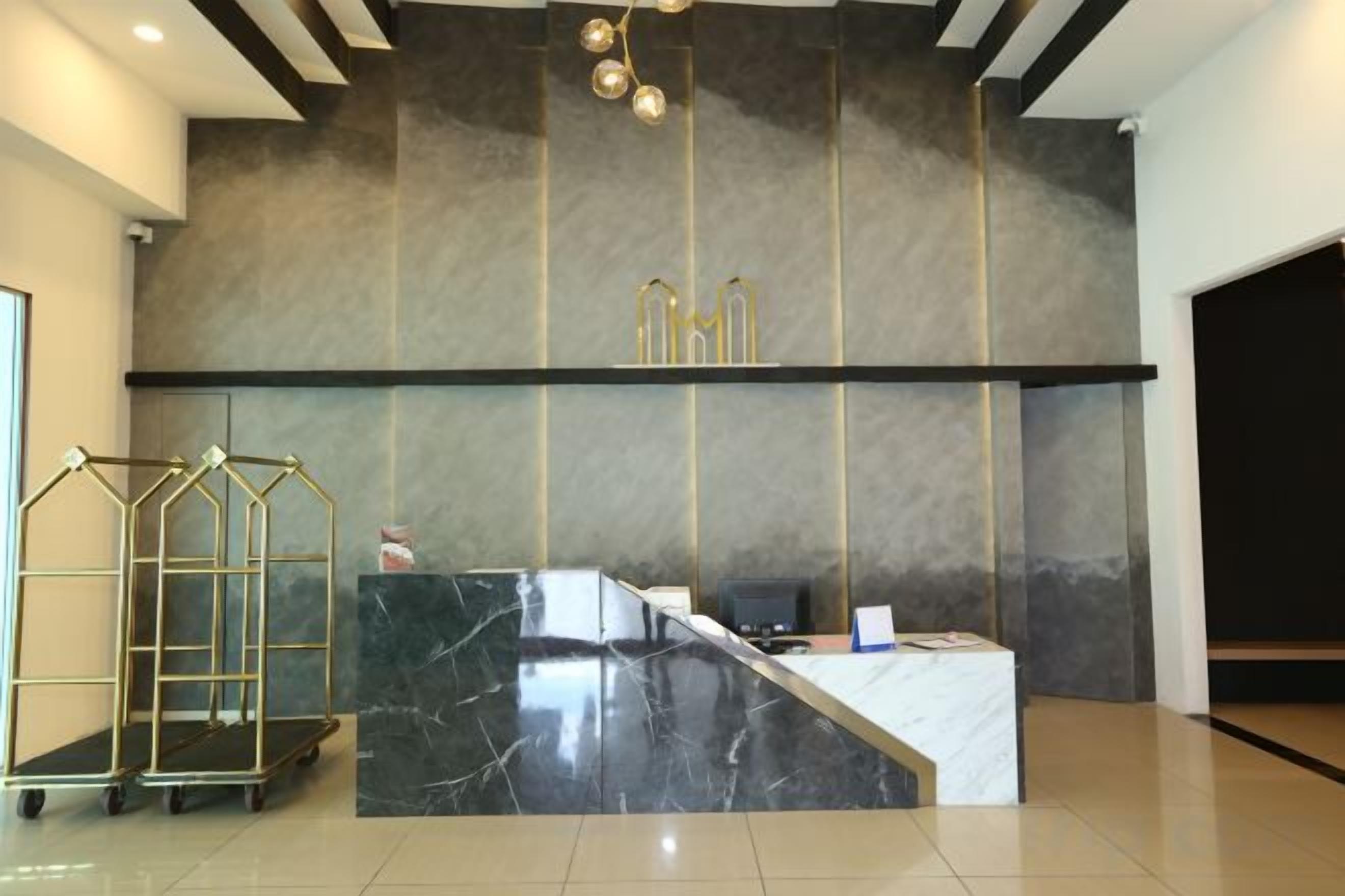 A reception desk with a marble counter, a gold-framed desk lamp, and a modern ceiling design.