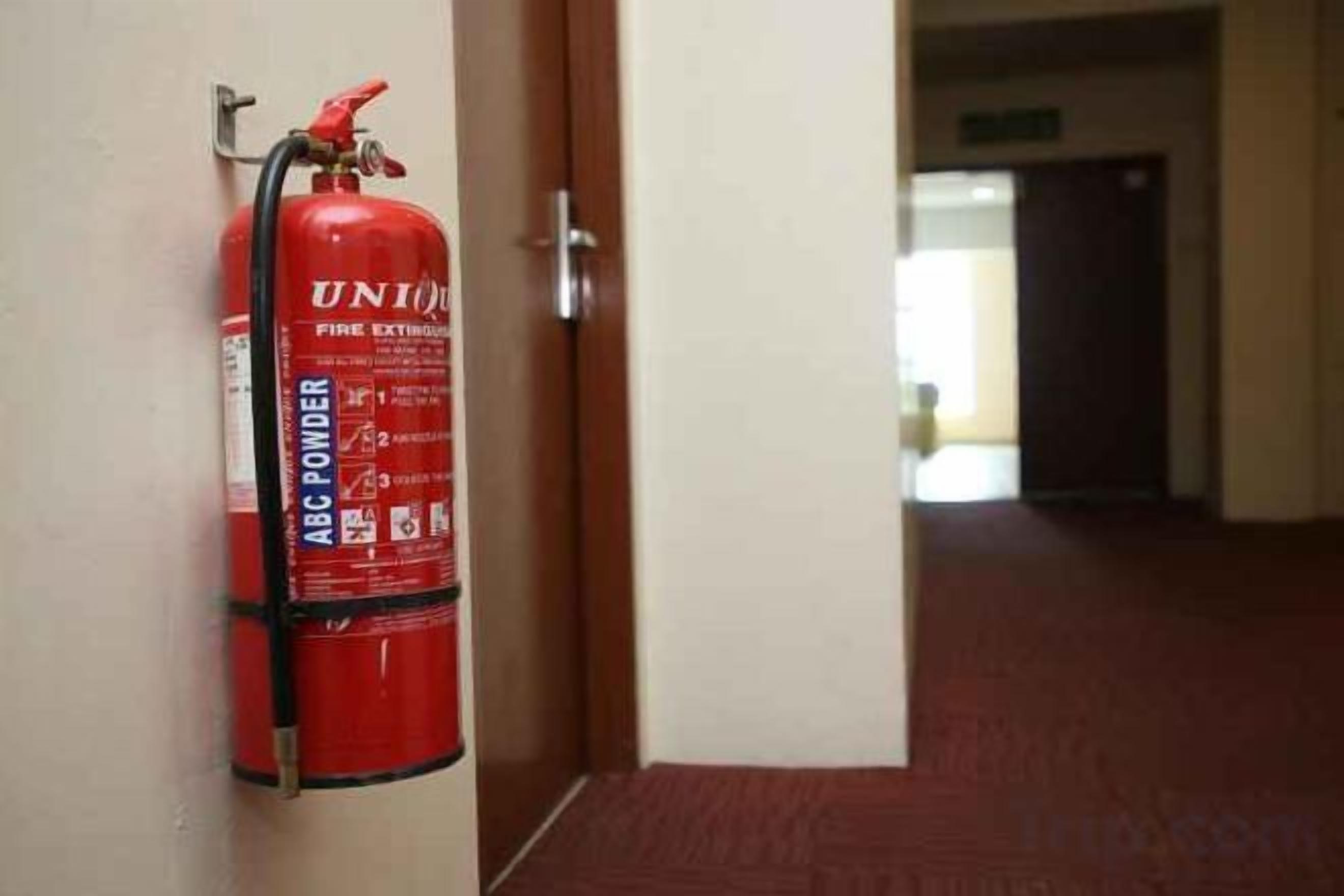 A fire extinguisher mounted on a wall in a hallway.