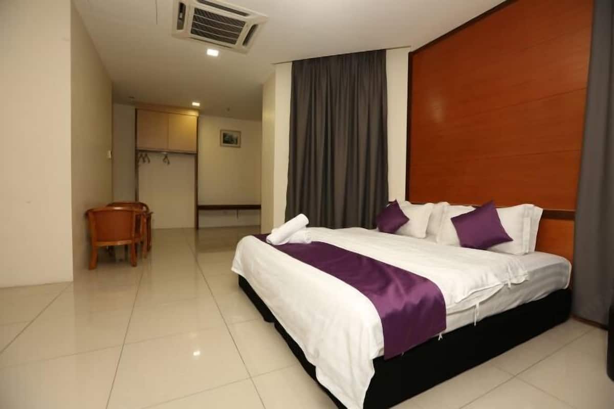 A hotel room with a bed, a desk, and a chair.