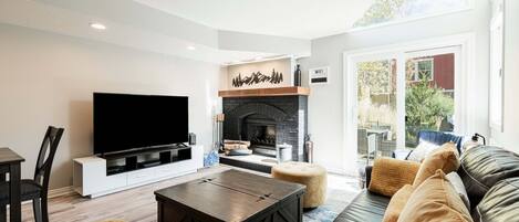 A living room with a fireplace, a flat-screen TV, a sofa, and a coffee table.