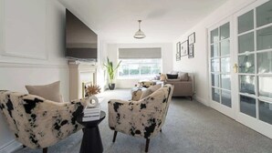 A spacious living room with a fireplace, a large window, and a sliding glass door. - Modern 5BR * Game Room * Free Parking * Sleeps 10 (Hornchurch)