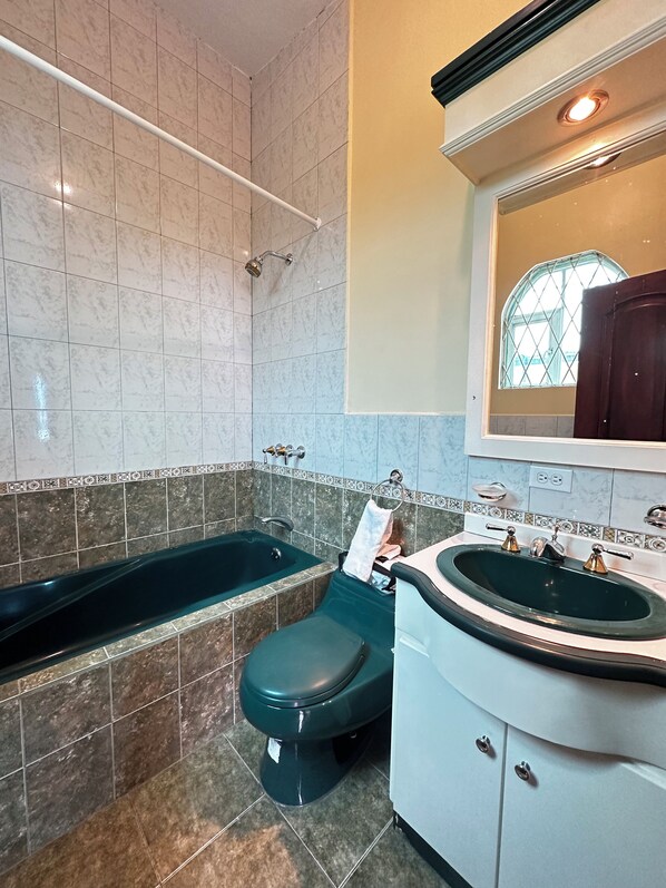 Un baño con bañera, inodoro y lavabo.