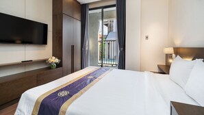 A hotel room with a bed, a flat-screen TV mounted on the wall, a nightstand with a lamp, and a view of the outside balcony. - DHTS Business Hotel & Apartment (Ho Chi Minh City)