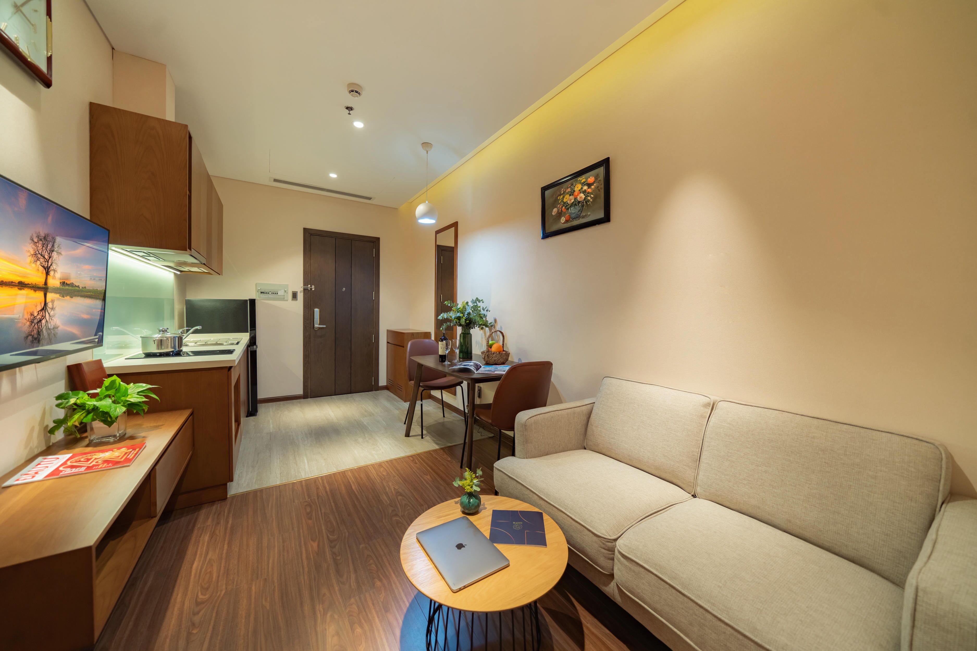 A modern living room with a sofa, a coffee table, and a dining area with chairs and a table.