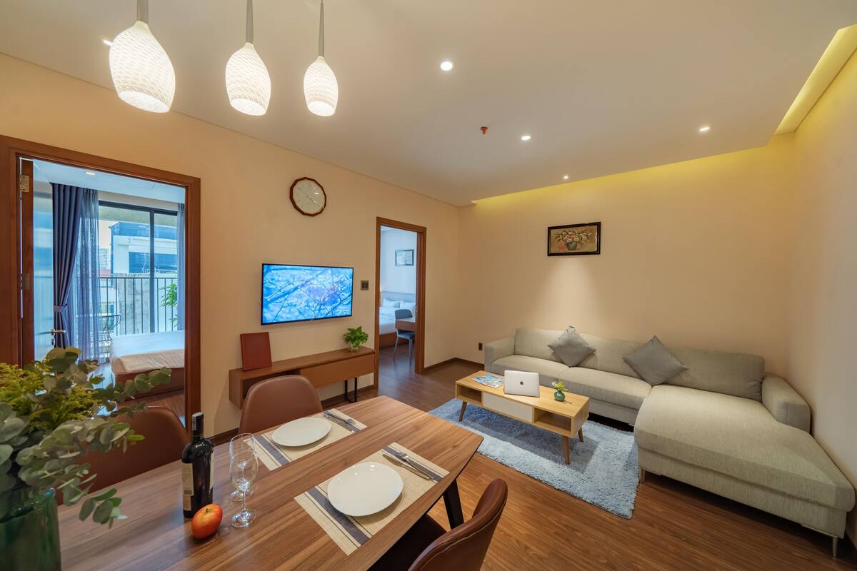 Ein modernes Wohnzimmer mit Holzesstisch, einer Couch und einem Fernseher.