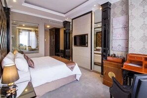 Relax in comfort with a large bed, mounted TV, and convenient side table.