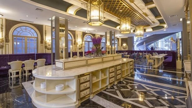 A spacious lobby with a marble floor, a central bar area, and a staircase leading to an upper level. - D'Primahotel Bandung (Sukajadi)