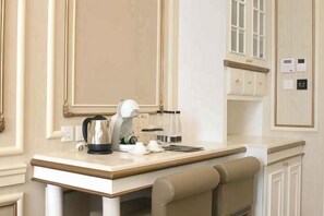 Relax in a serene space with a large bed, small table, and comfortable seating area.