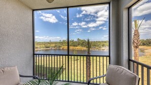 A balcony with a view of a lake and surrounding vegetation.