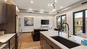 A modern kitchen with a large island, wooden cabinets, and a built-in oven. - Sunrise Escape at Downtown Whitefish (Whitefish)