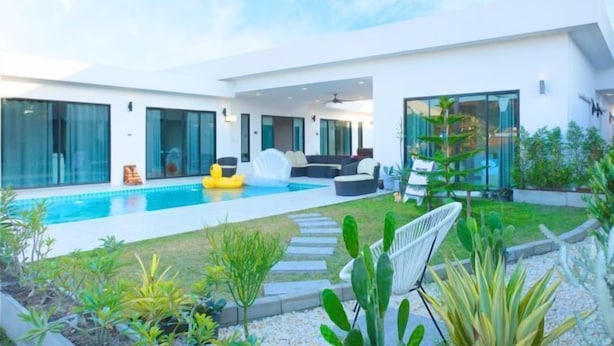A modern house with a swimming pool, outdoor seating, and a garden. - Natree Pool Villa Pattaya (Pattaya)