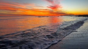 A beach with waves at sunset.