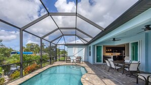 A covered outdoor swimming pool with a patio area, a dining table, and chairs. - Private Pool & Dock, Charlotte County Villa 5890 (Charlotte County)