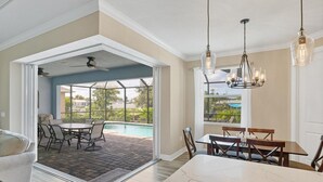 A spacious living area with a pool view, a dining area, and a kitchen with a marble countertop. - Private Pool & Dock, Charlotte County Villa 5890 (Charlotte County)
