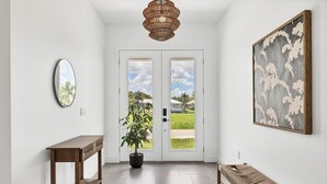 A hallway with a wooden bench, a potted plant, a mirror, and a framed artwork. - Charlotte County Villa 5892 - Pool Home Retreat (Charlotte County)