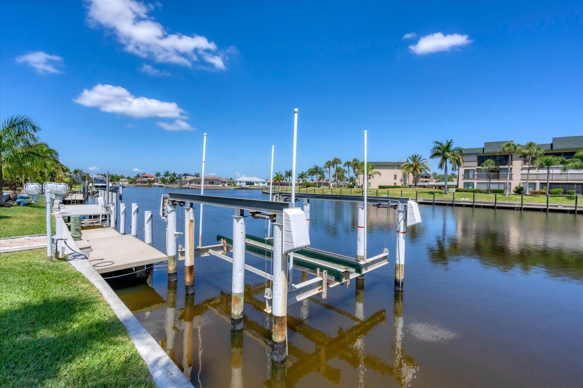 A marina with docks and boats, surrounded by greenery and buildings.