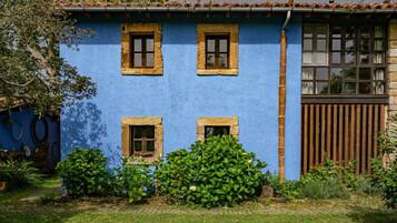 Un edificio azul con tres ventanas y una puerta de madera.
