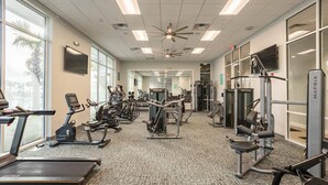 A gym with treadmills, elliptical machines, and weightlifting equipment. - Orlando Villa 6462: Private Pool & Resort Amenities (Orlando)