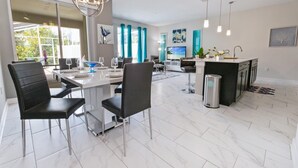 Eine moderne Küche mit Essbereich, großen Fenstern und Blick ins Freie.