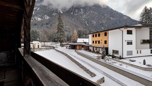 A snowy mountain landscape with buildings and a wooden balcony. - Apartment 'Loderhof Blumenwiese' with Mountain View, Shared Garden & Wi-Fi (Sand in Taufers)