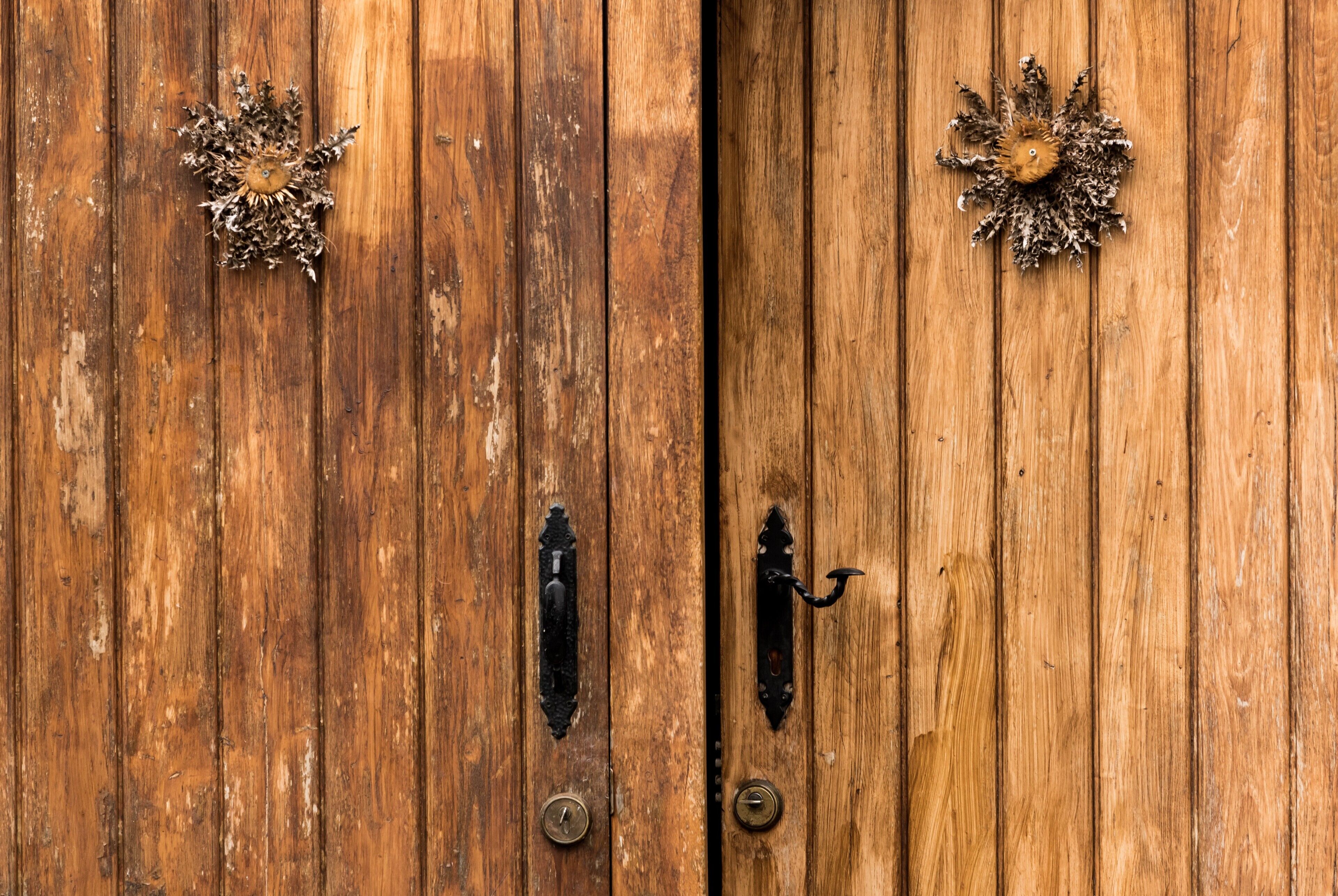 A wooden door with metal handles and a keyhole.